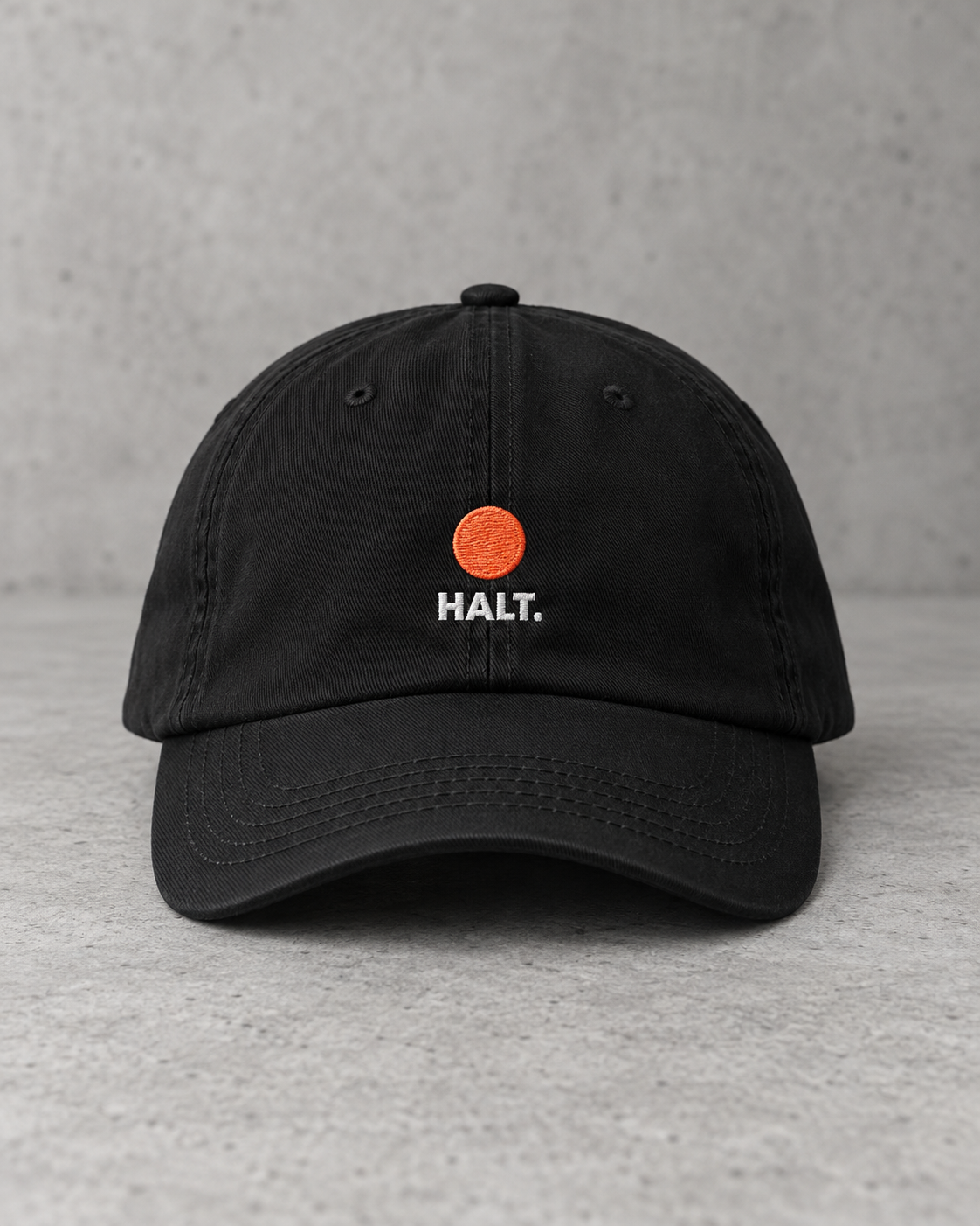 HALT. Dot Cap - black low-profile baseball cap with embroidered coral dot logo, front view
