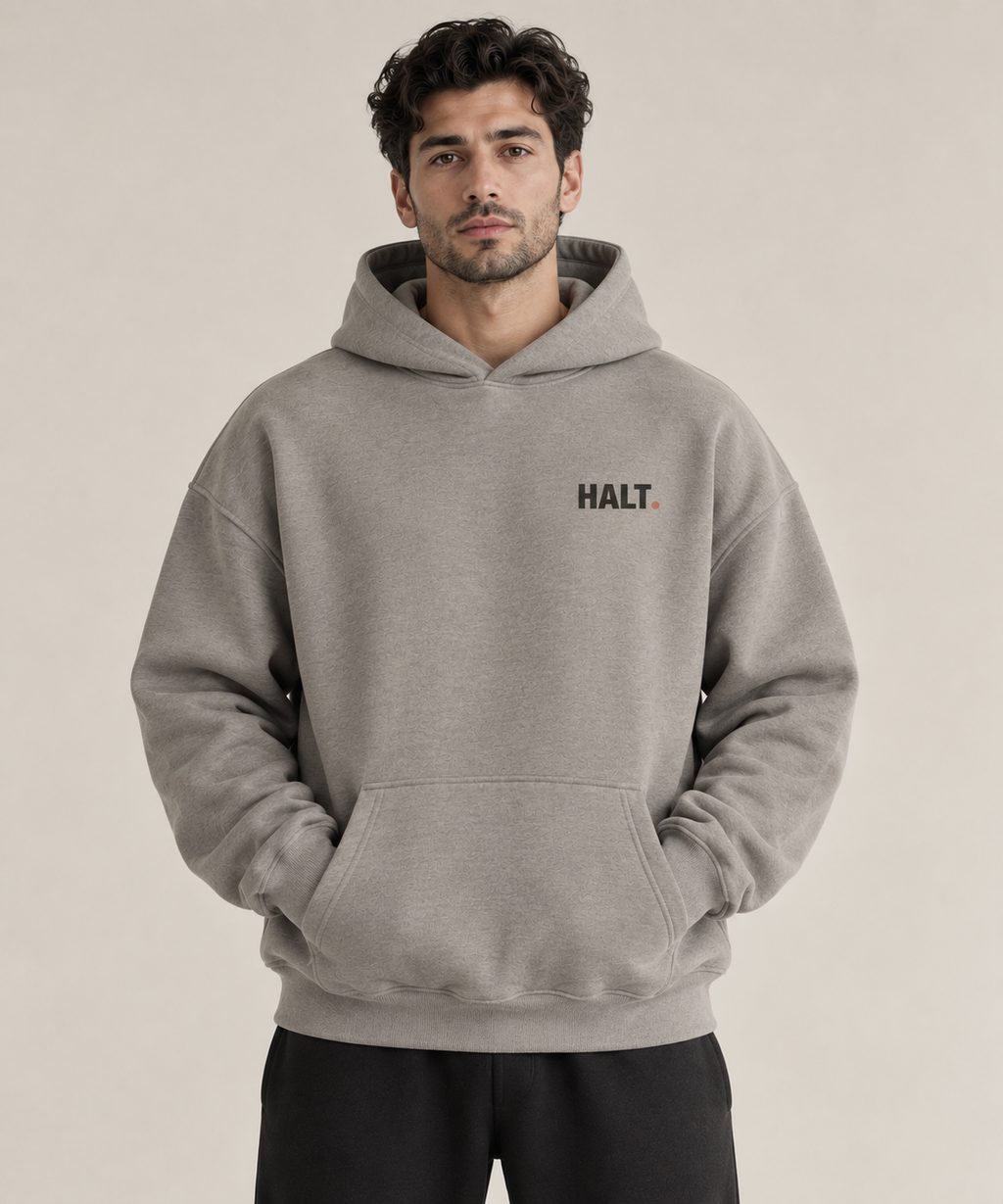 HALT. Slow Down oversized heather grey hoodie, front view with small black chest logo, unisex heavyweight streetwear pullover
